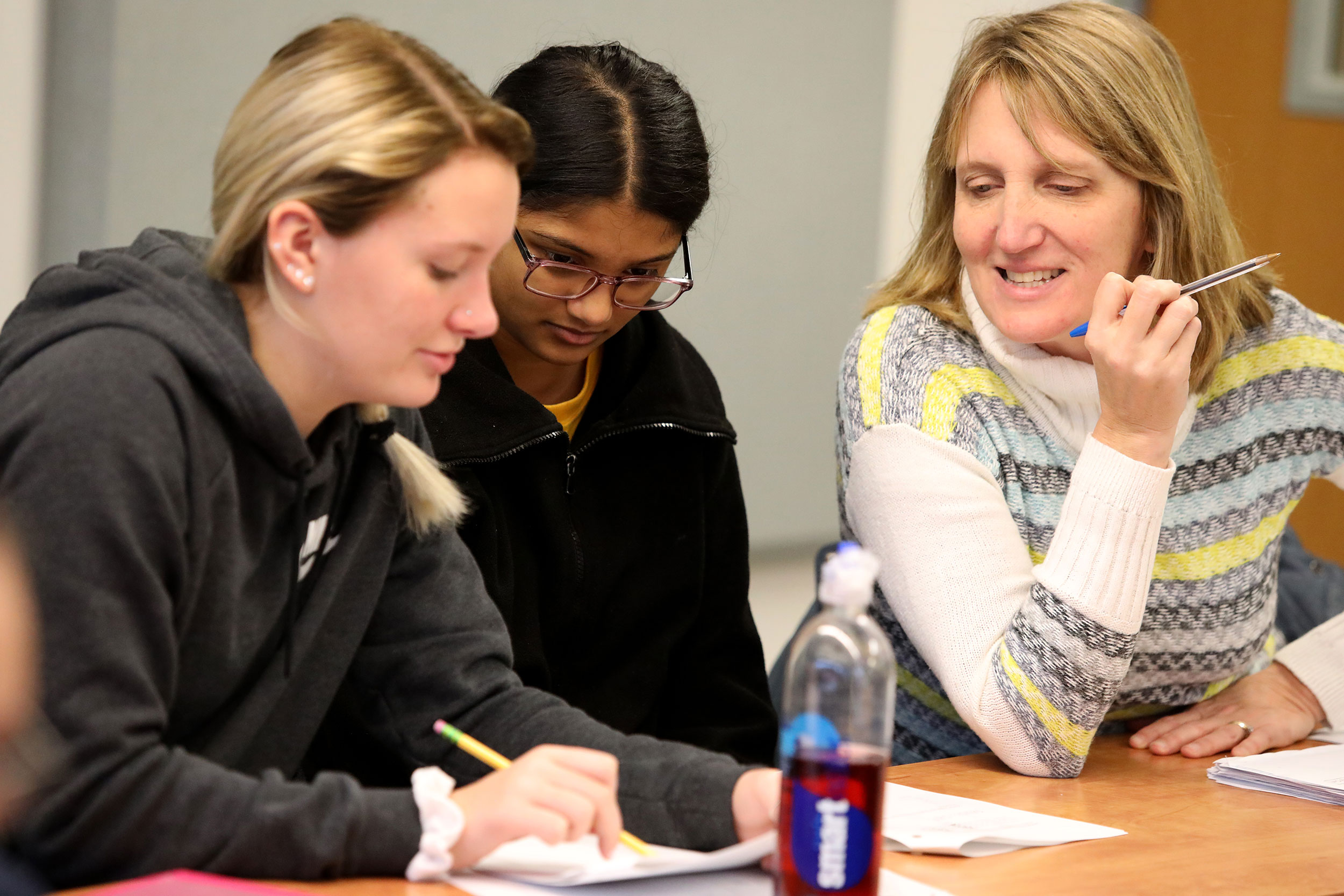 Teacher and students looking in a book