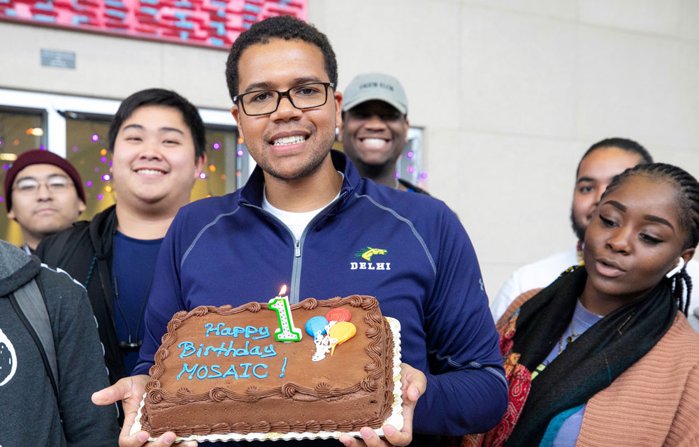 Students gathered around holding a birthday cake