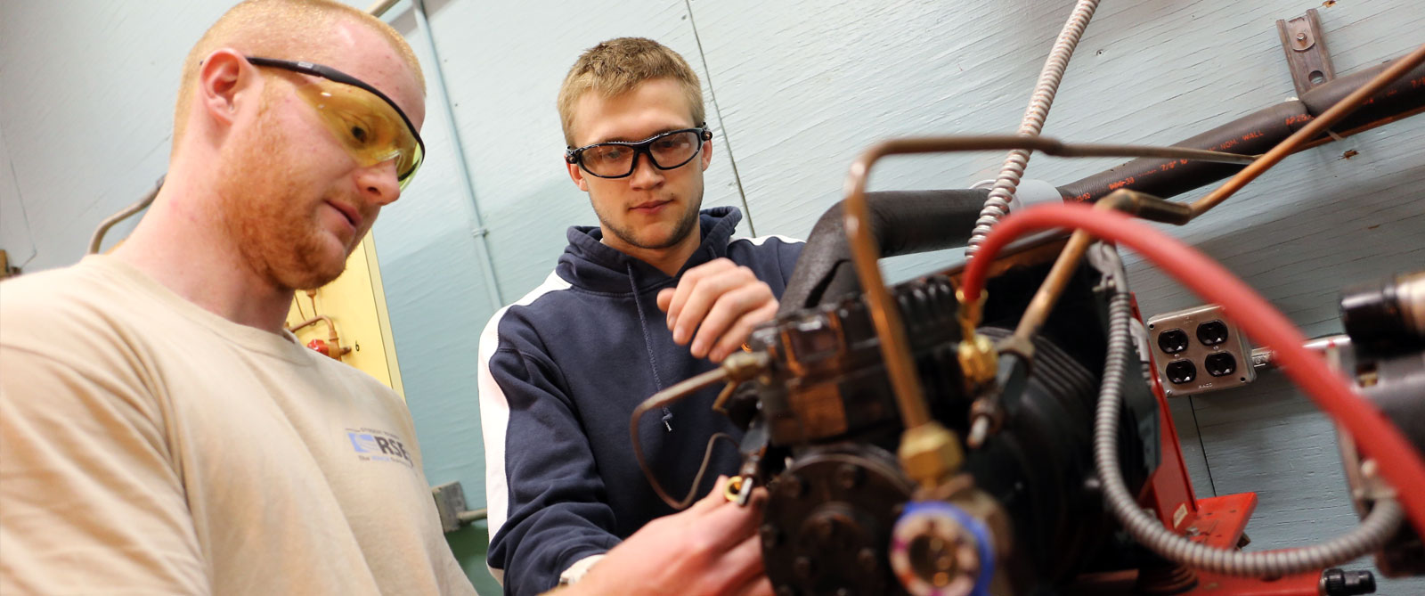 Two students working on machinery