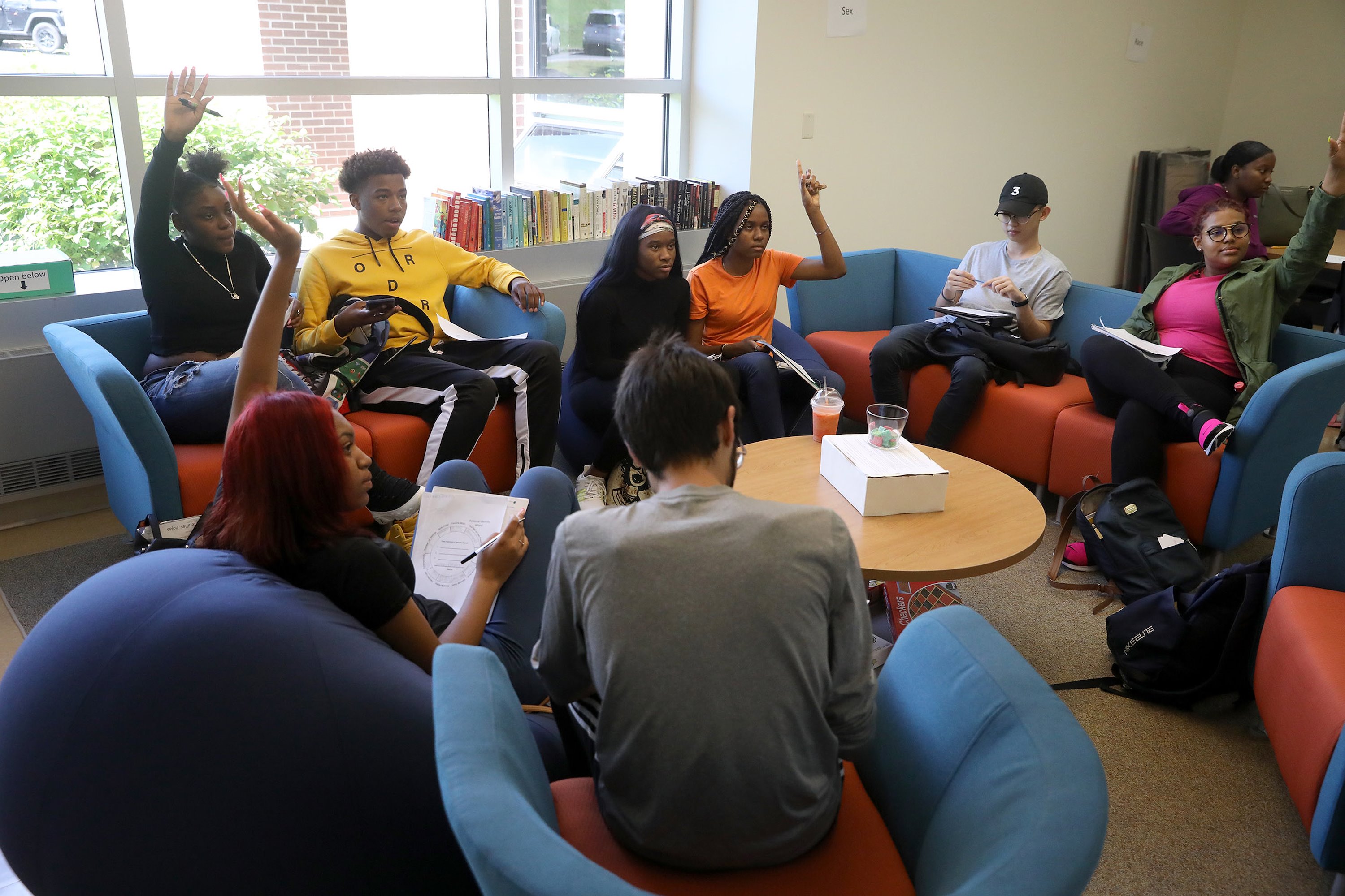 Students sitting in chairs around the room having a discussion