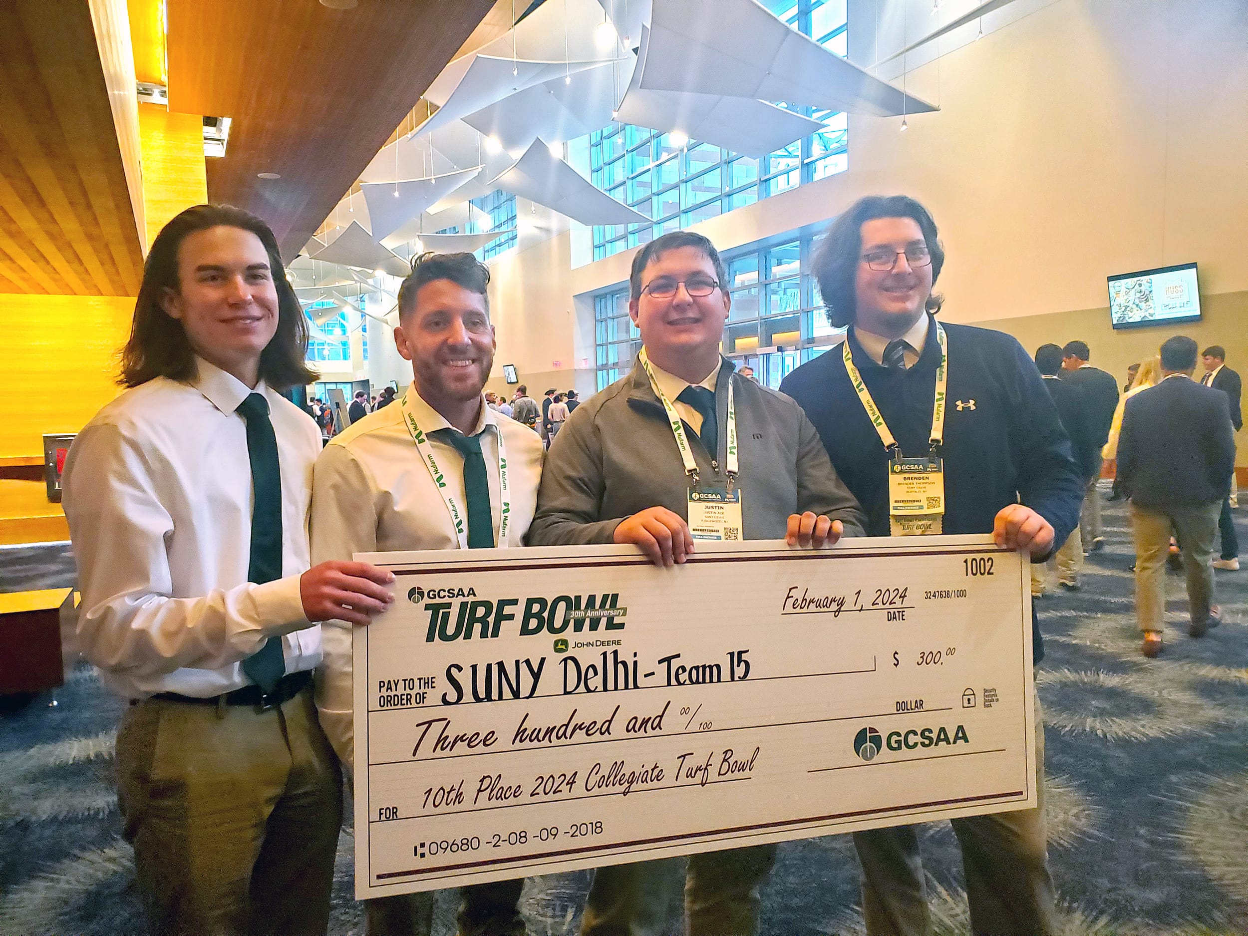 Four Golfing Students holding a large check