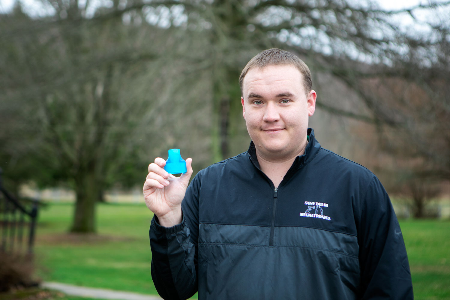 SUNY Delhi student holding up life saving piece for scuba gear