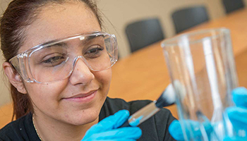 Student dusting beaker for fingerprints