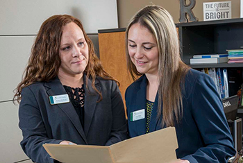 Two students reviewing a file