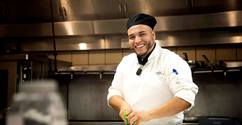 Julio Chavez in the kitchen cutting vegetables