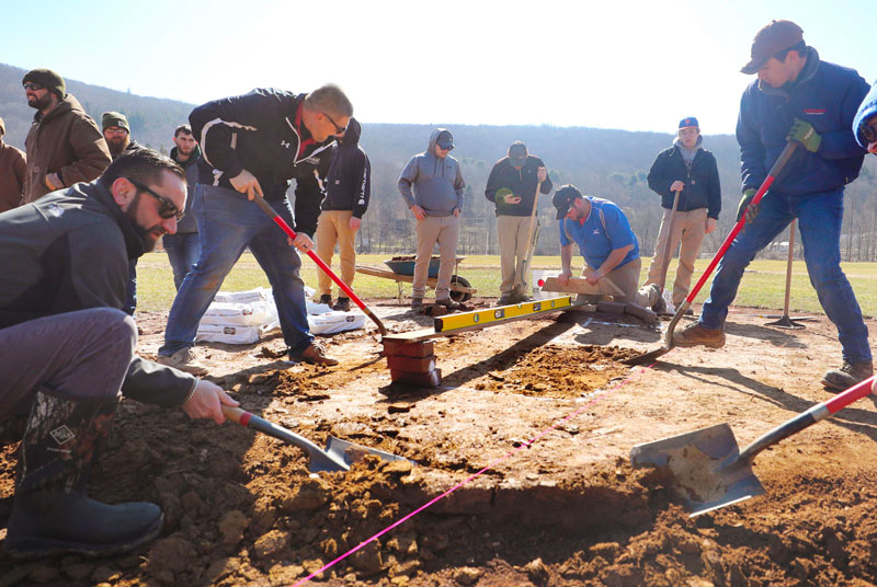 Students digging as part of sports field renovation at American Legion