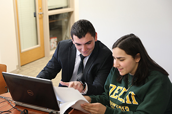 Student helps another student with their taxes on their laptop