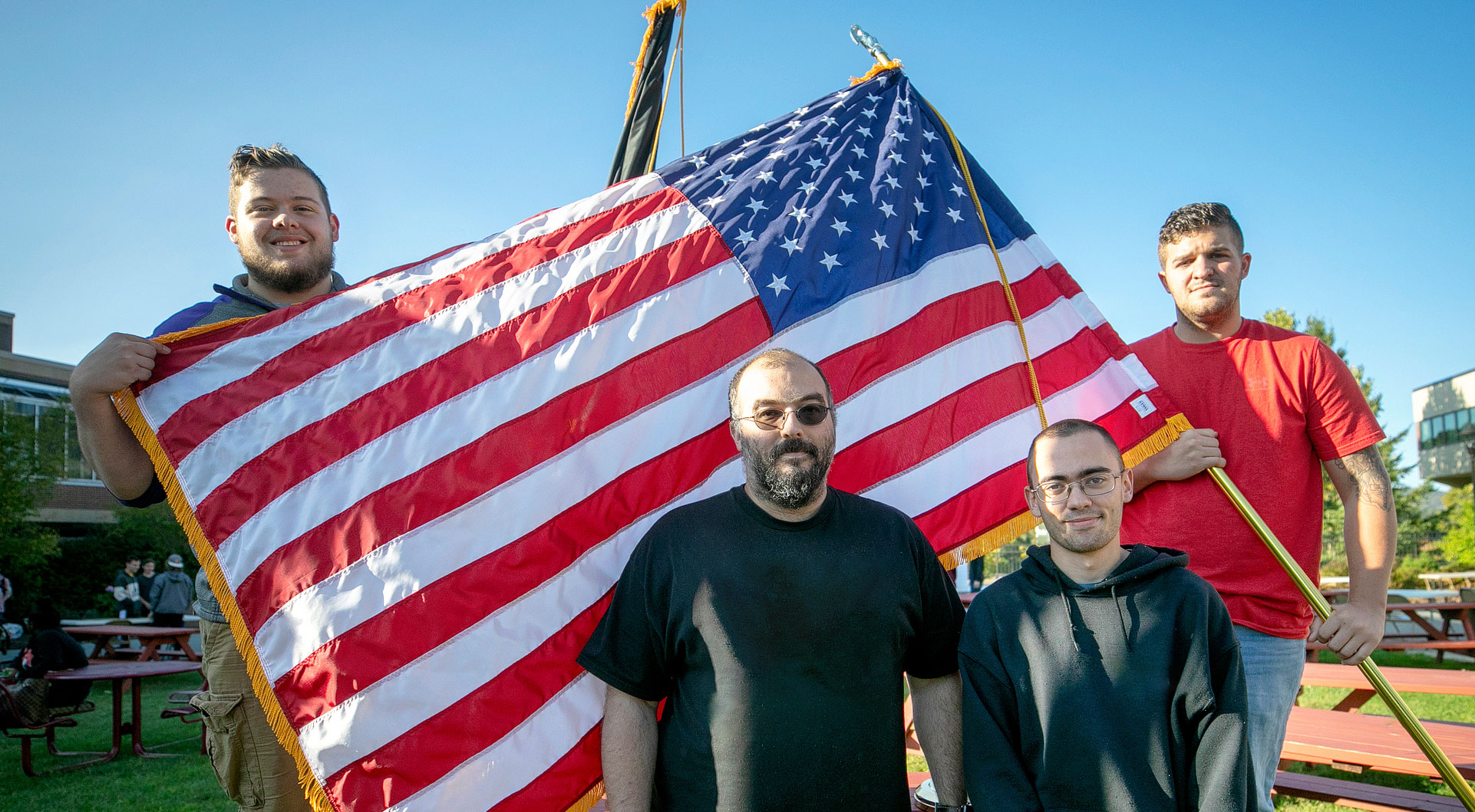 Military veterens holding up american flag