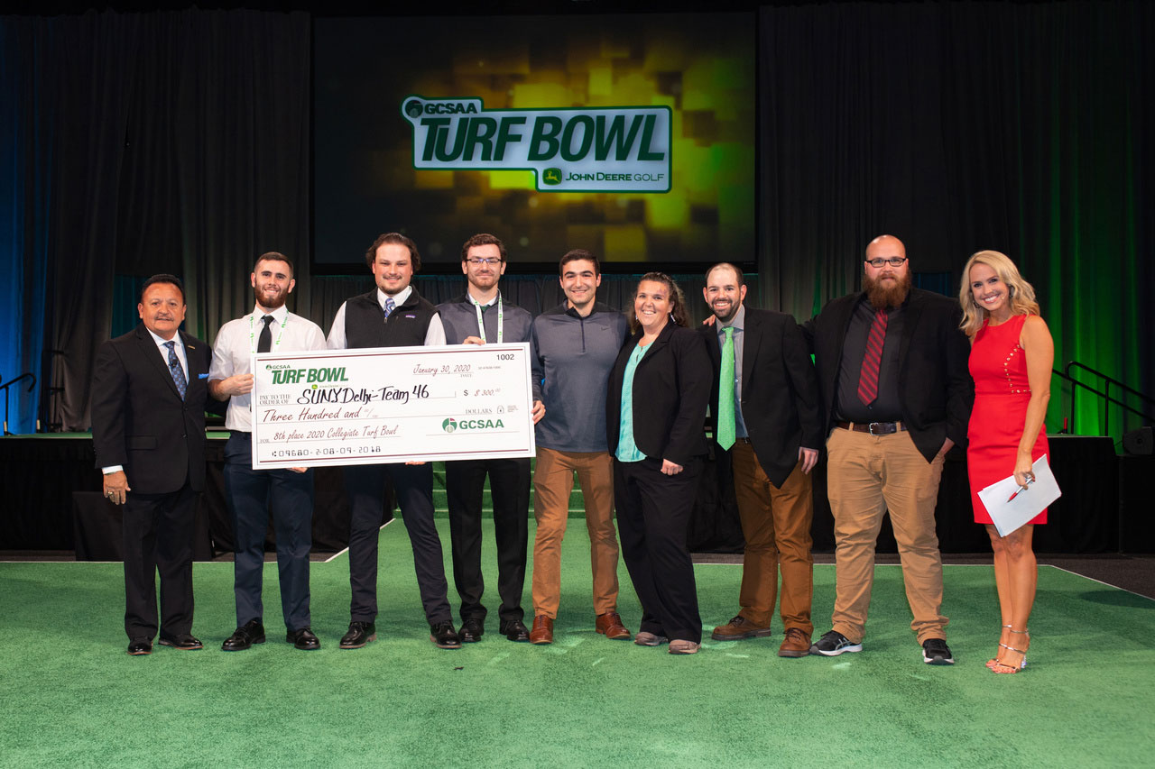 Students and professors holding a big check