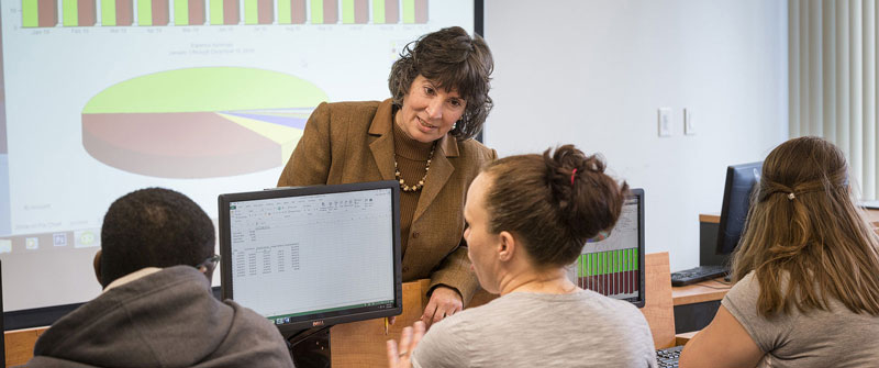 Faculty member Barbara Sturdevant in computer lab with students