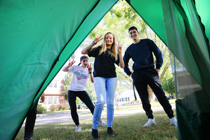 Students looking through open side of a tent