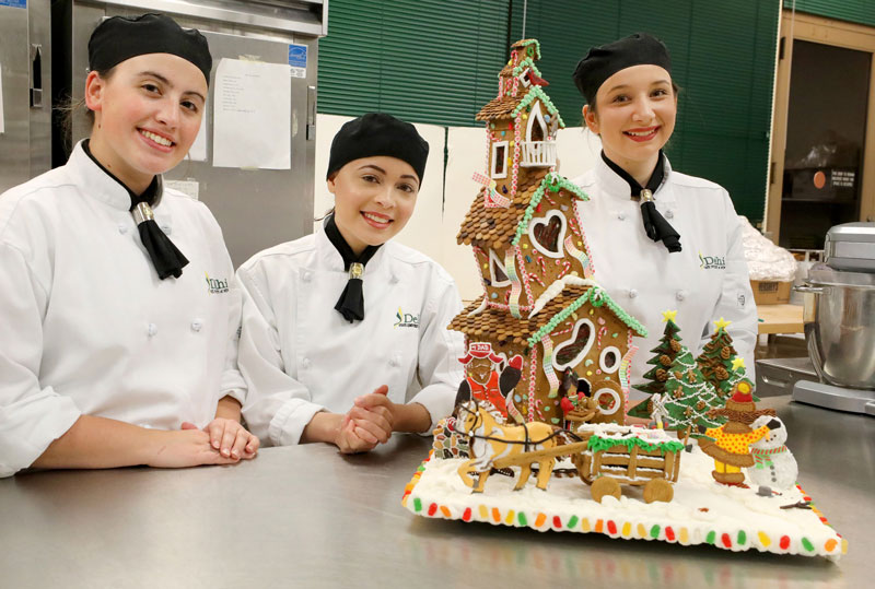 Baking students and gingerbread house they created 