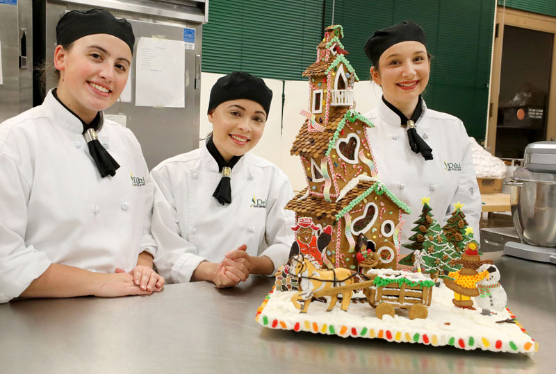 Baking students and gingerbread house they created