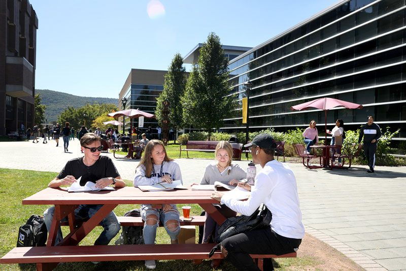 Students sitting at picnic table outside Farrell Center