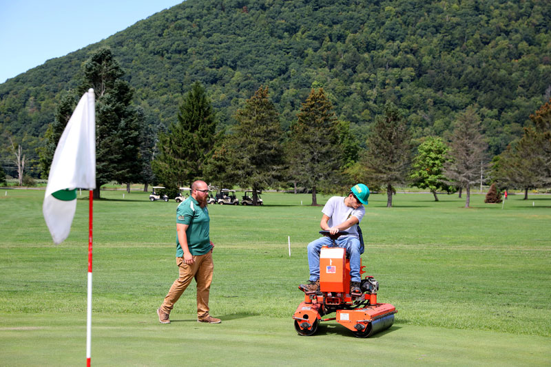 Students grooming college golf course