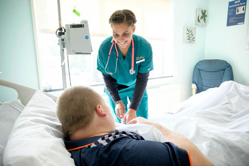 Student talking to patient in bed