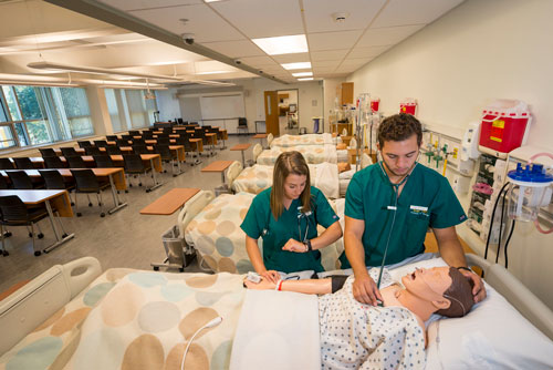 Students practicing on mannequin in lab