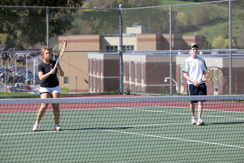 Students playing tennis on outdoor court