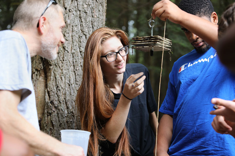 Student and faculty studying sample outdoors