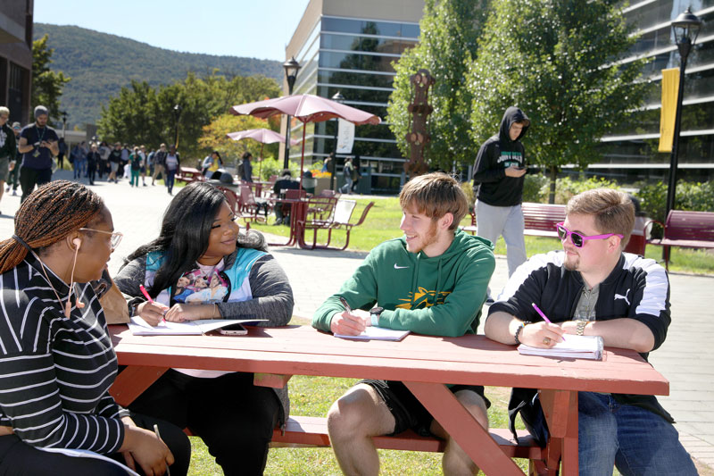Students talking outside at picnic table