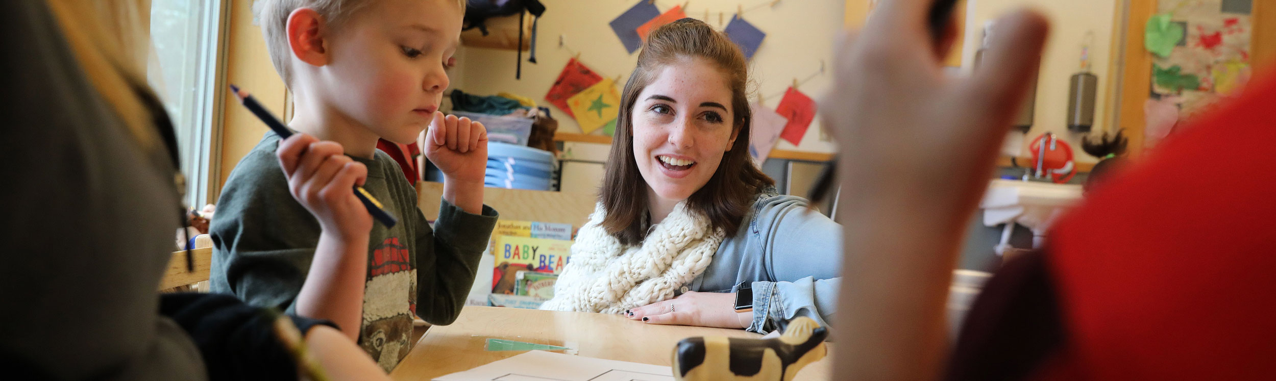 Teacher at table with small adult