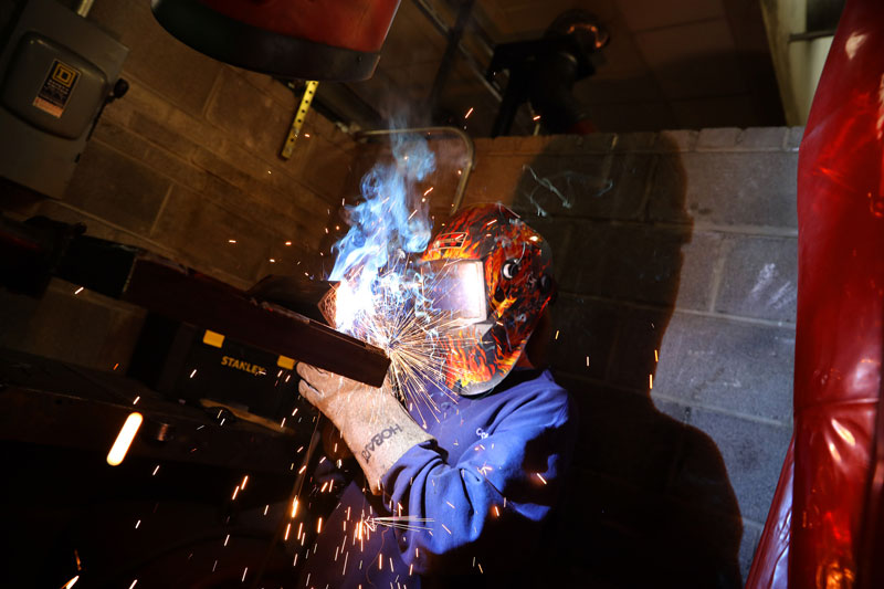Student welding in lab in protective gear