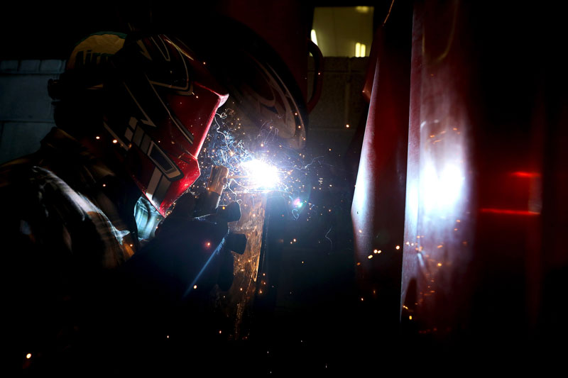 Student welding in lab in protective gear