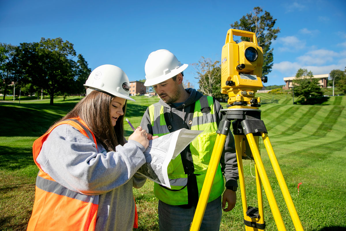 Students surveying green grassy area