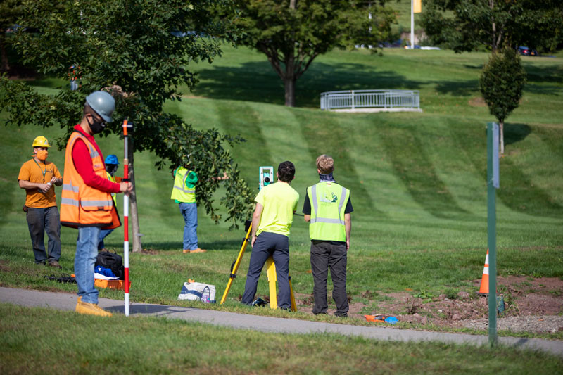 Students surveying green grassy area
