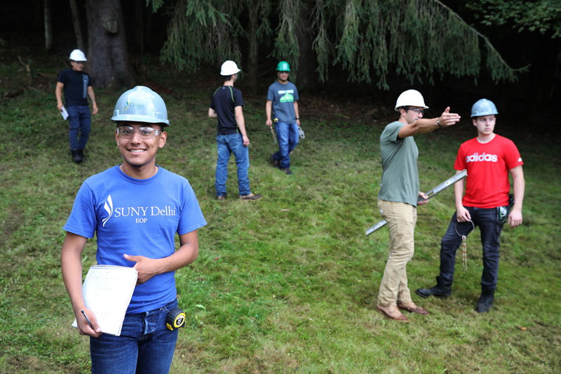 Construction students in hard hats working outdoors