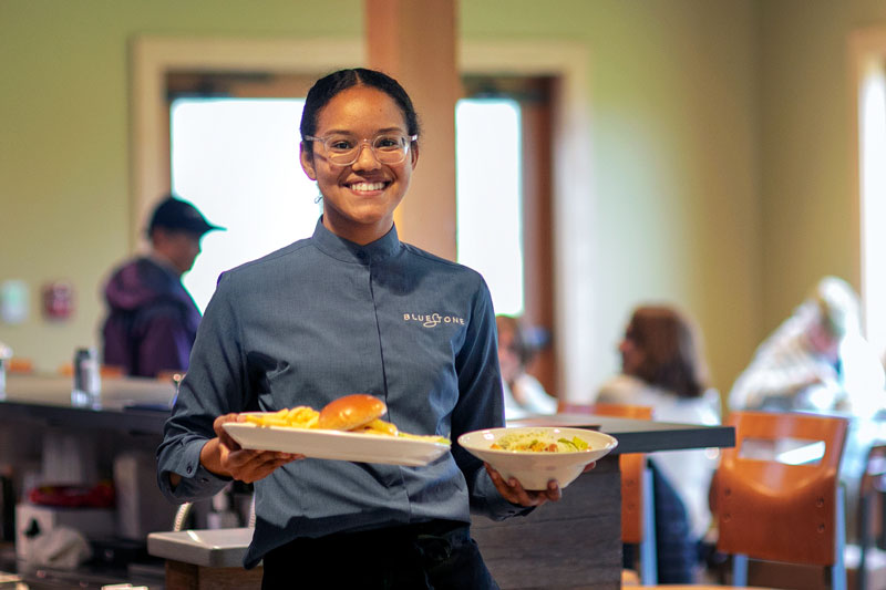 Hotel & Restaurant Management student carrying plates of food at Bluestone