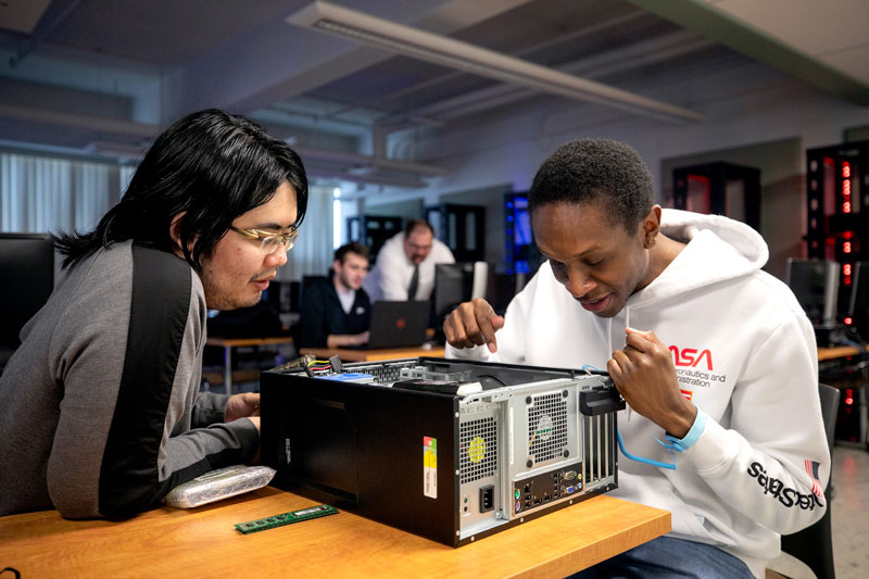 Students inspecting inside of computer