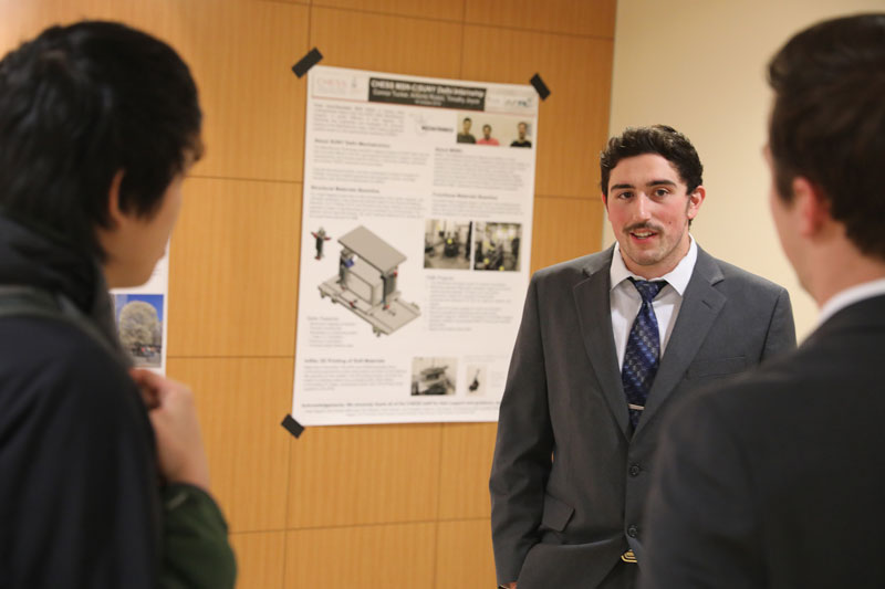 Student standing in front of poster on wall