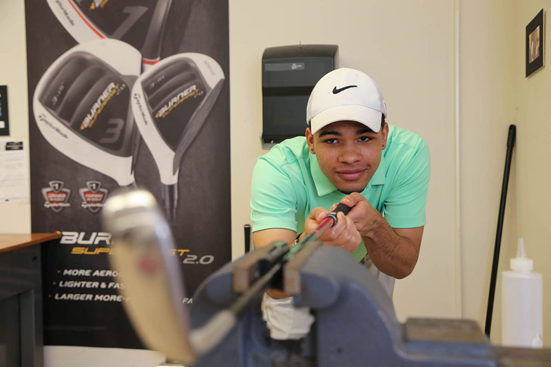 Student inspecting golf club