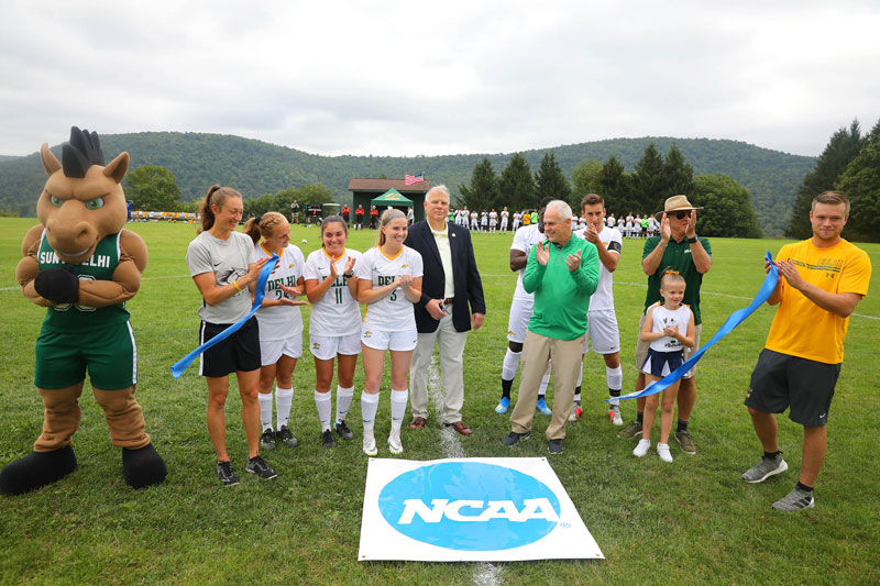 Student athletes outdoors beside NCAA sign