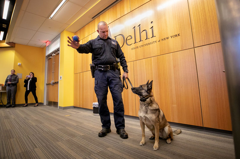 Law enforcement officer and K-9 companion in classroom