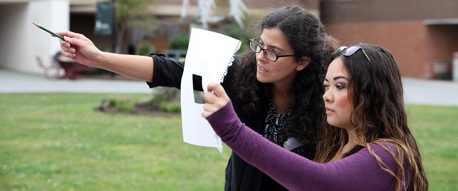 Teacher and student outside working on a project