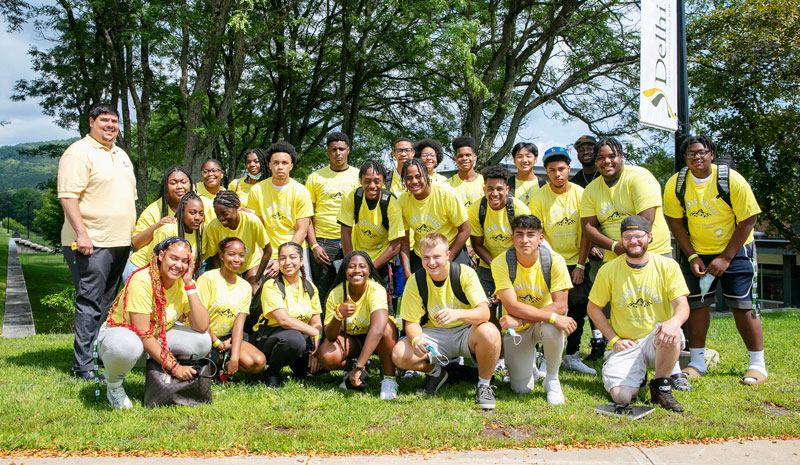 Many students wearing yellow shirts posing for a picture