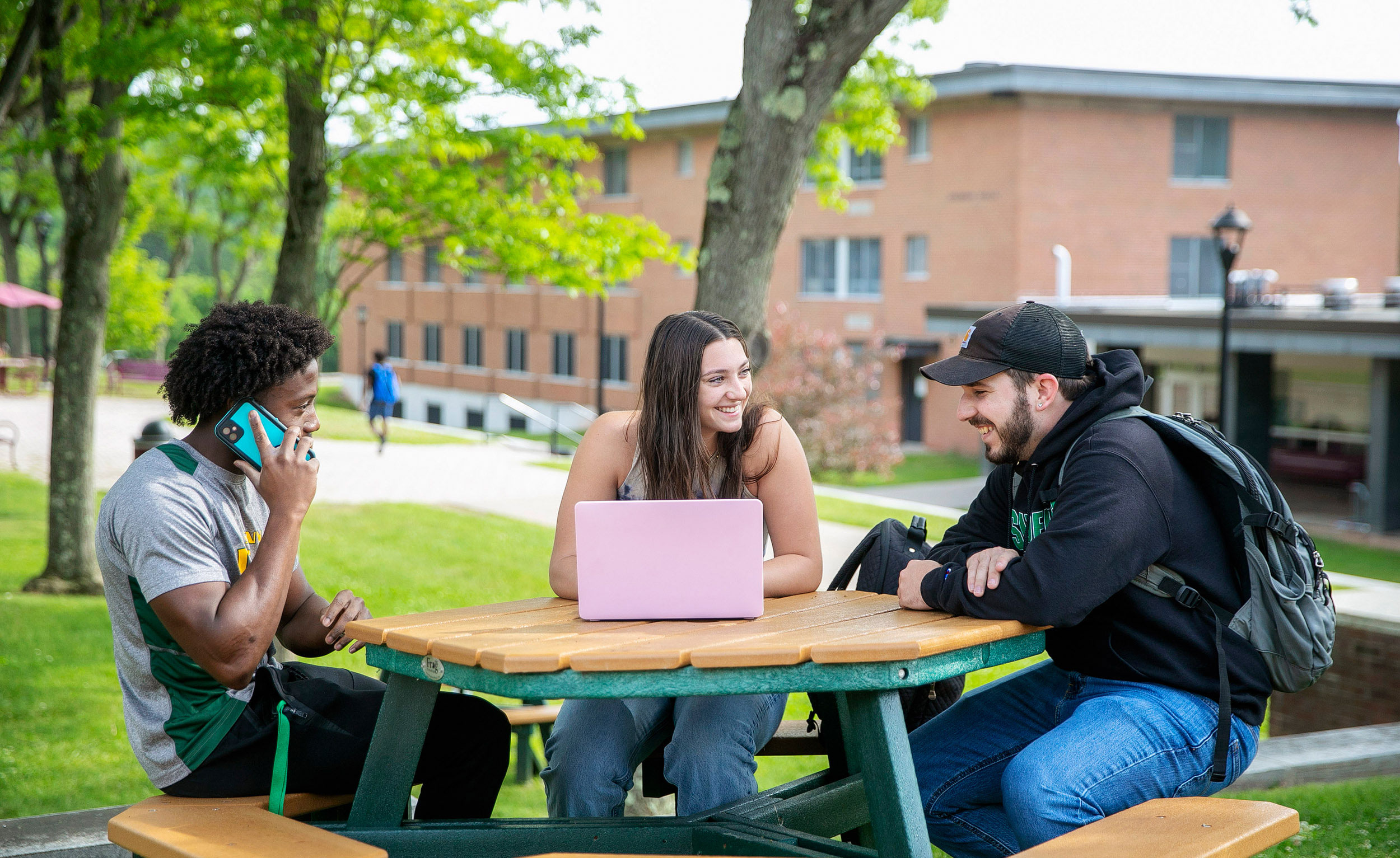 Students studying outside with laptops
