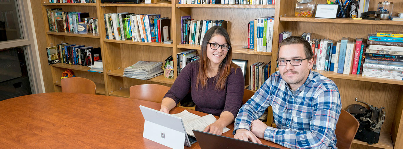 Students studying in the library with laptops