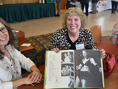 Alumni displaying a book with her picture