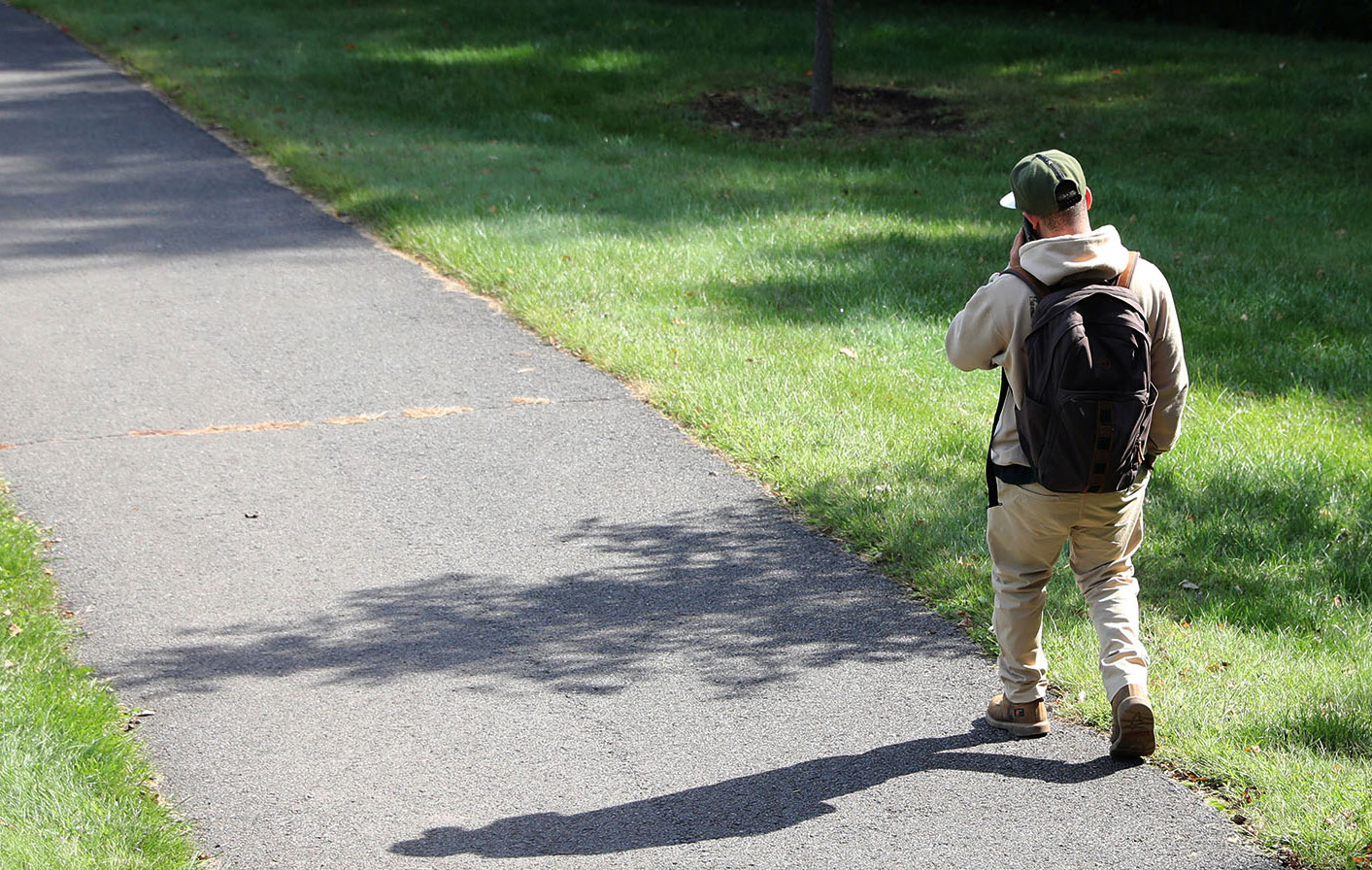 Student walking talking on his phone