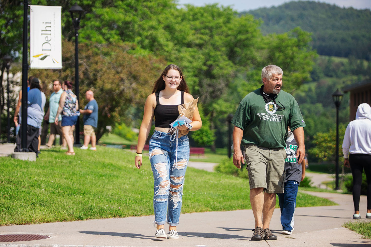 Daughter and father walking on sidewalk