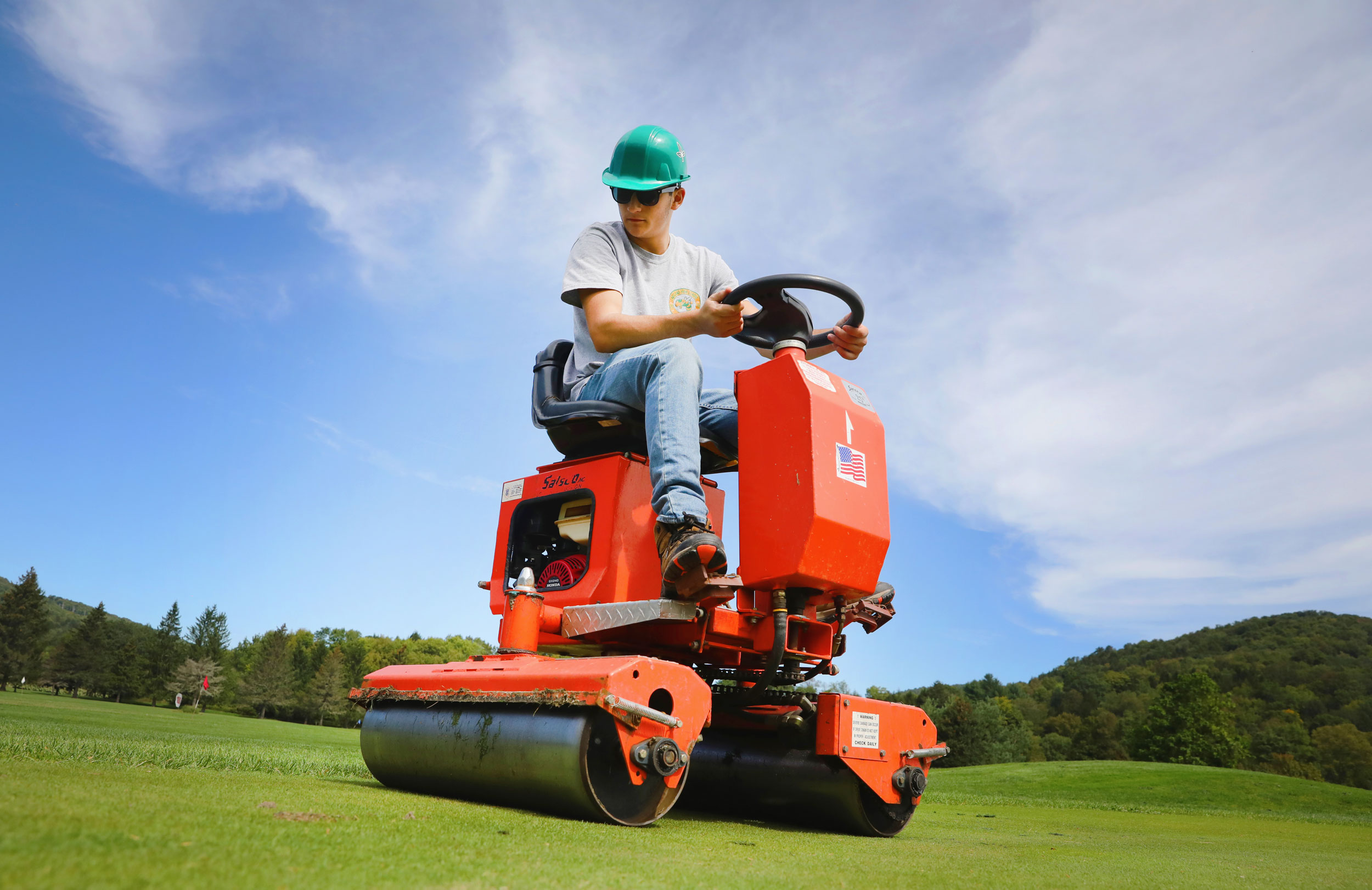 Student driving machinery on golf course