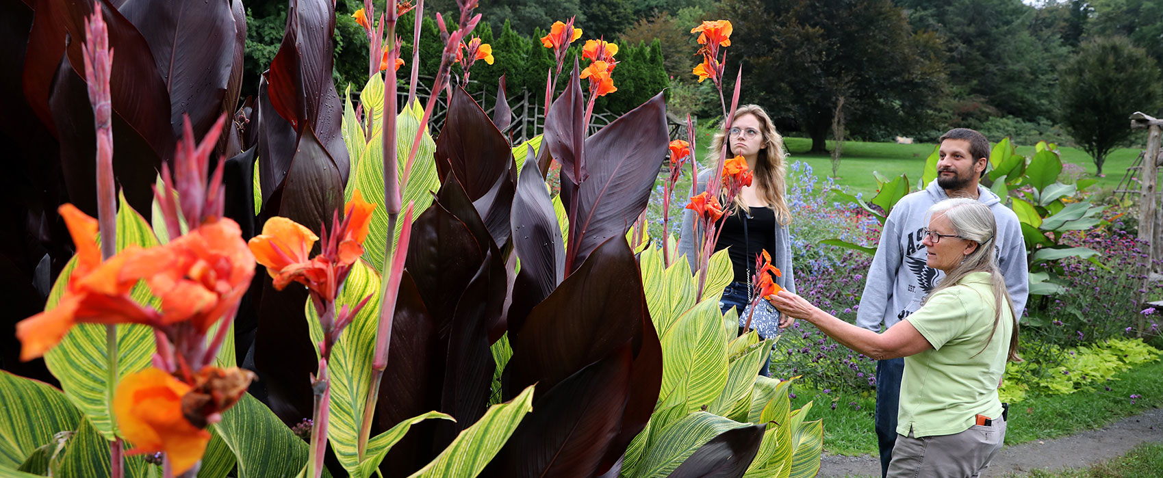 Professor and students maintaining flower bed
