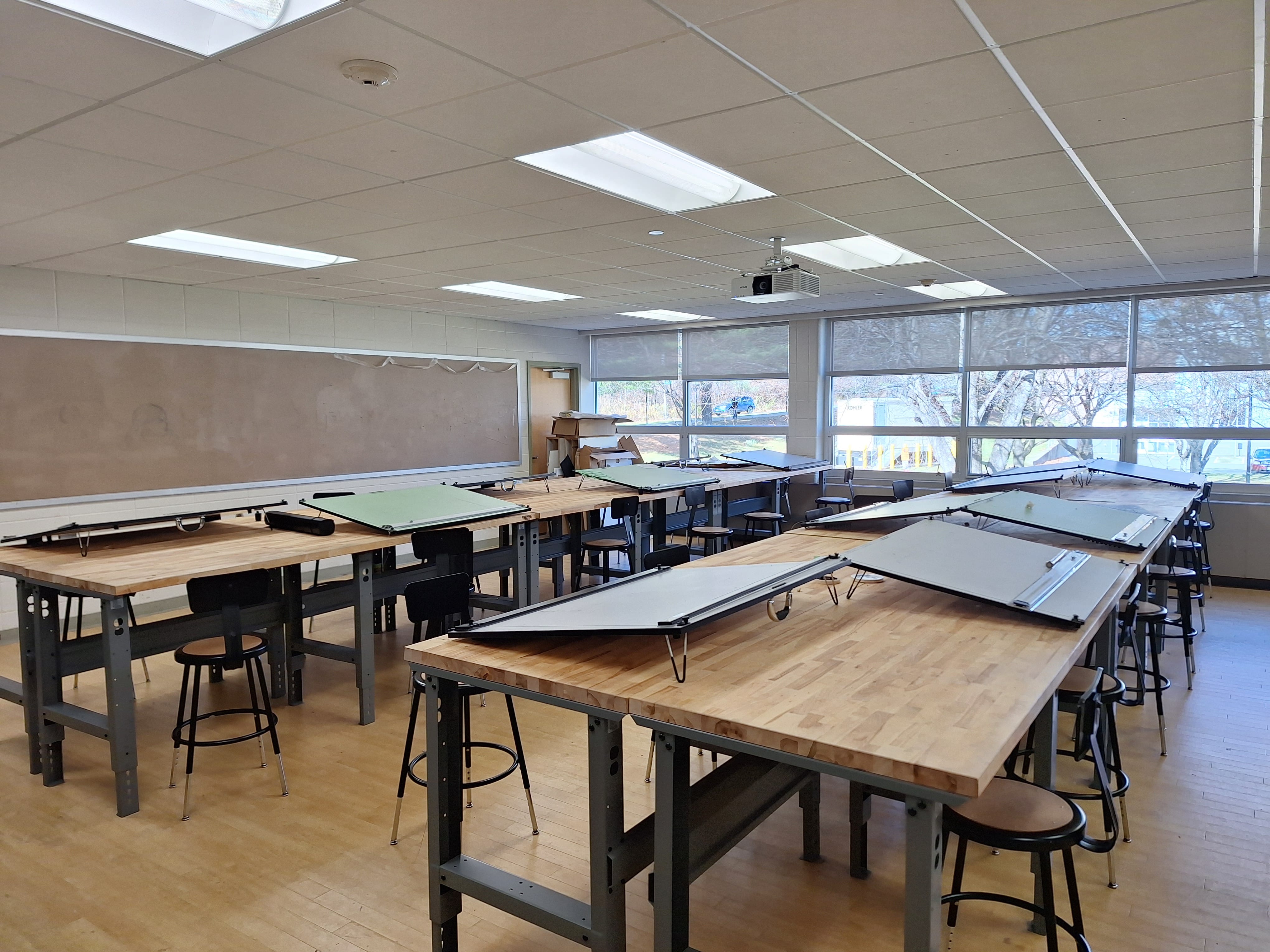 A classroom with drafting tables and stools, perfect for architecture majors or use as drafting studios.