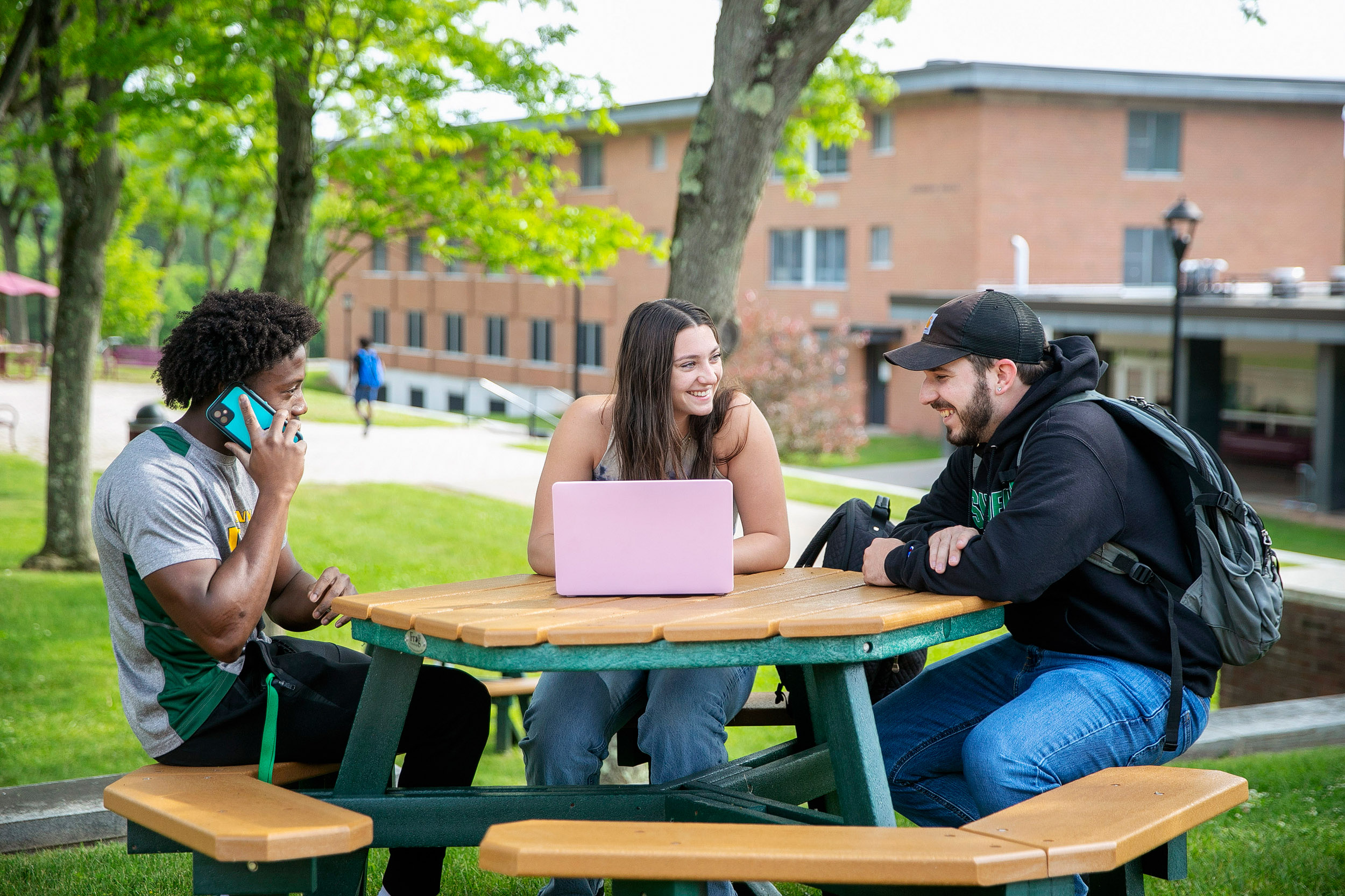 Student sitting outside under trees